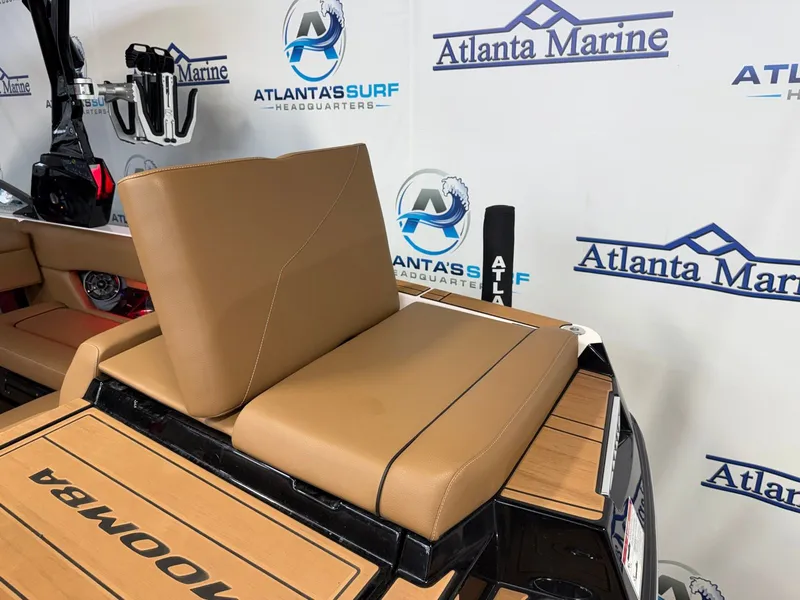 Slide: The Image of 2024 Moomba Mojo with brown seats and Atlanta Marine logo in the background. - 11