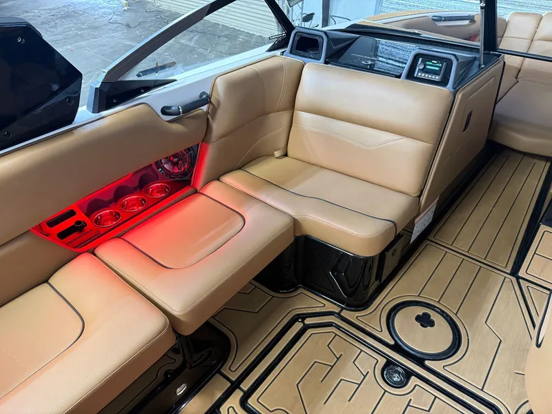 Slide: The Image of Interior of a 2024 Moomba Mojo with beige leather seats and red lighting. - 17