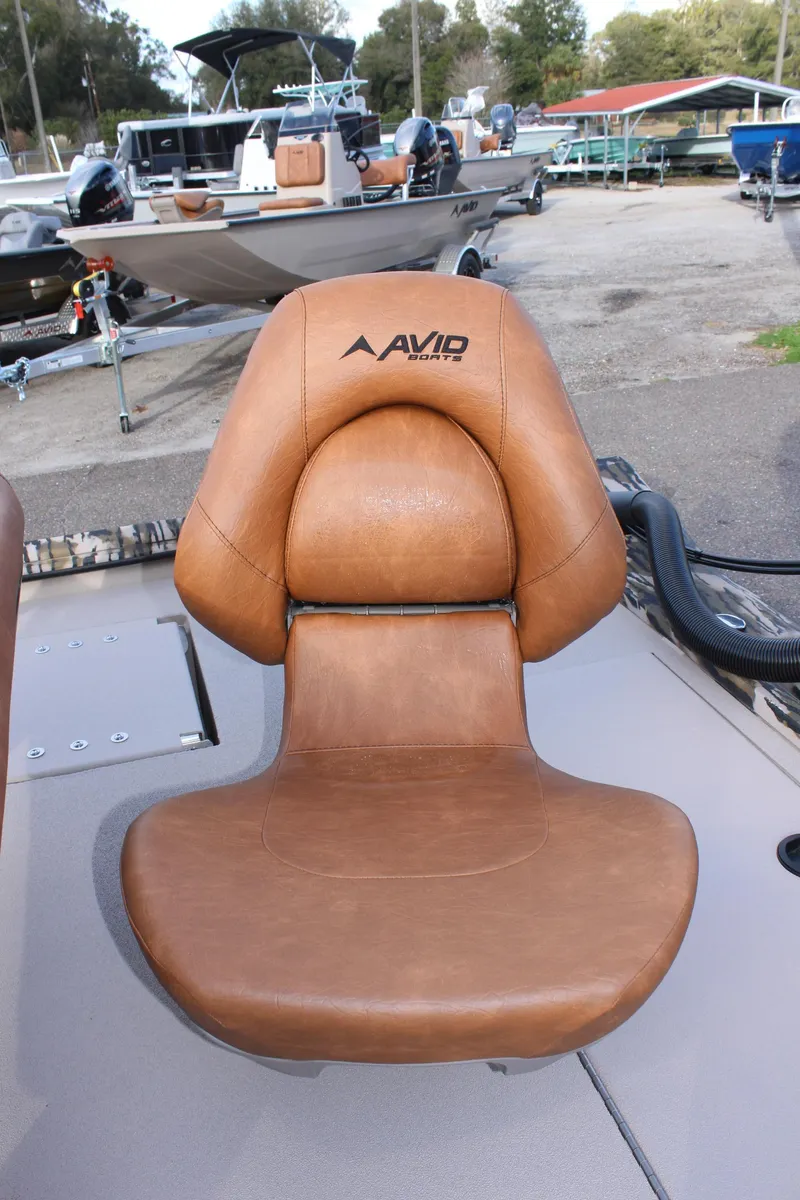 Slide: The Image of Avid 20 Rogue 2024 boat seat in brown leather, docked with other boats. - 18