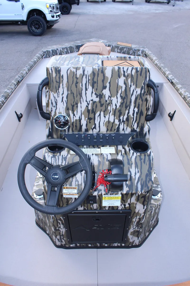 Slide: The Image of 2024 Avid 20 Rogue boat interior with camouflage console and steering wheel. - 26