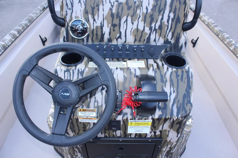 Slide: The Image of 2024 Avid 20 Rogue boat dashboard with camo design, steering wheel, and control panel. - 27
