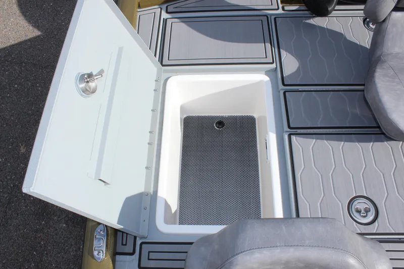 Slide: The Image of Open storage compartment on 2024 Avid 19 XB boat with gray seating and flooring. - 12