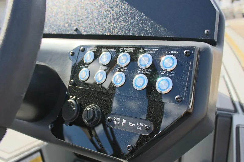 Slide: The Image of Control panel of 2024 Avid 19 XB boat with various switches and indicators. - 18