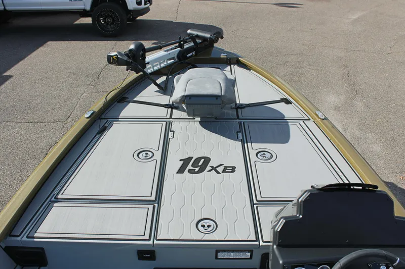 Slide: The Image of 2024 Avid 19 XB fishing boat deck with trolling motor and storage compartments. - 23