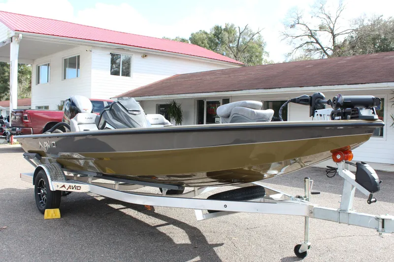 Slide: The Image of 2024 Avid 19 XB boat on a trailer in front of a house with a red roof. - 4