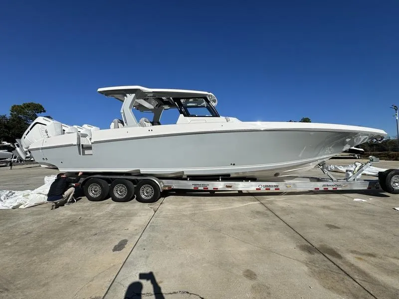 Slide: The Image of 2024 Fountain 38 SCX boat on a trailer in a parking lot under clear blue sky. - 2