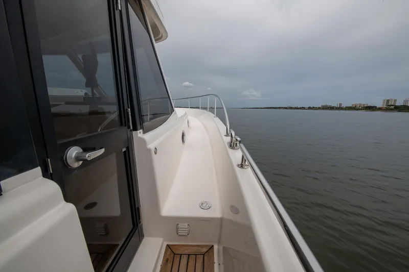 Slide: The Image of 2007 Maritimo Enclosed Fly Bridge yacht side deck with wooden flooring and stainless steel railings. - 23