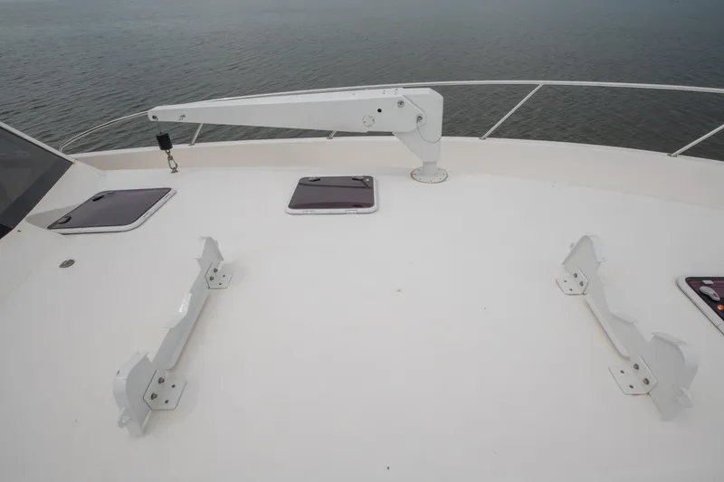 Slide: The Image of 2007 Maritimo Enclosed Fly Bridge deck with crane and hatch, overlooking calm waters. - 26