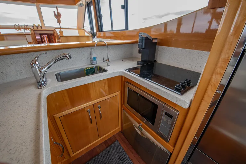 Slide: The Image of 2007 Maritimo Enclosed Fly Bridge kitchen with modern appliances and wooden cabinetry. - 42