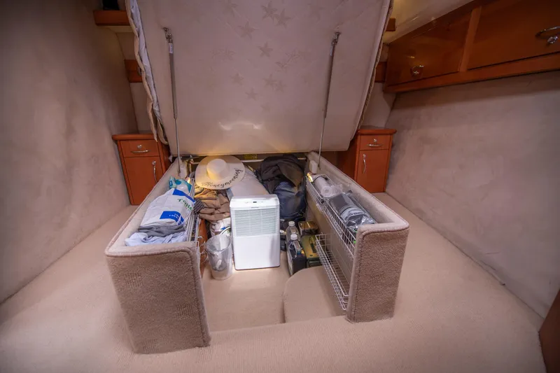 Slide: The Image of Under-bed storage in 2007 Maritimo Enclosed Fly Bridge yacht, organized with various items. - 48