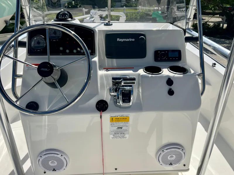 Slide: The Image of 2013 Boston Whaler MONTAUK boat console with steering wheel, Raymarine electronics, and cup holders. - 14