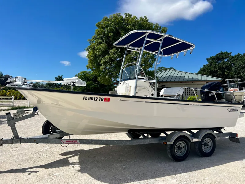 Slide: The Image of 2013 Boston Whaler MONTAUK boat on trailer with blue canopy. - 2