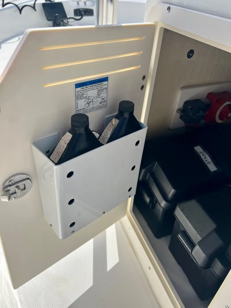 Slide: The Image of 2013 Boston Whaler MONTAUK storage compartment with oil bottles and battery boxes. - 25