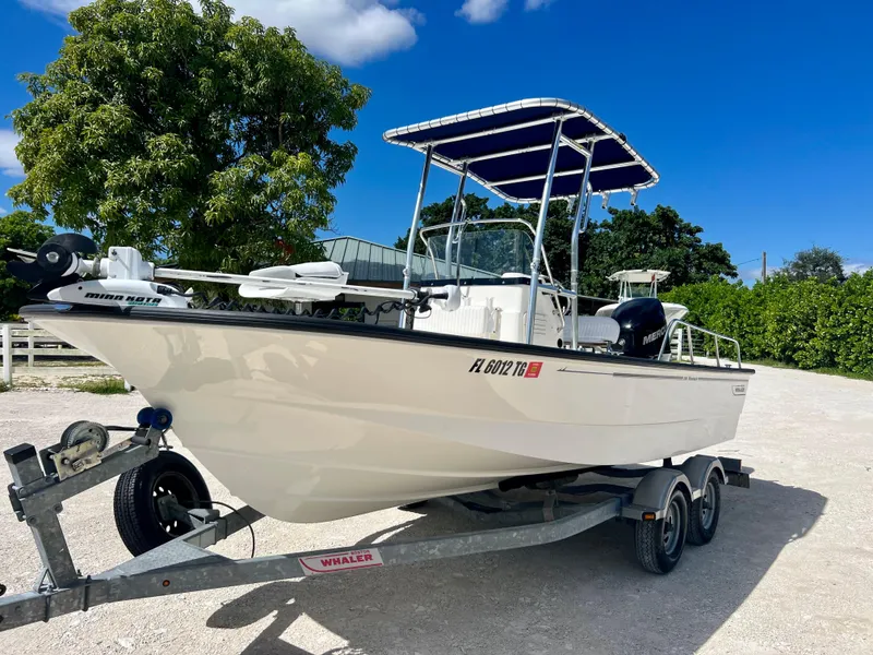 Slide: The Image of 2013 Boston Whaler MONTAUK boat on a trailer with a blue canopy. - 3