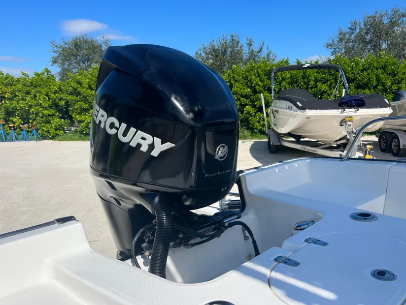 Slide: The Image of 2013 Boston Whaler MONTAUK with Mercury outboard motor in a sunny outdoor setting. - 31