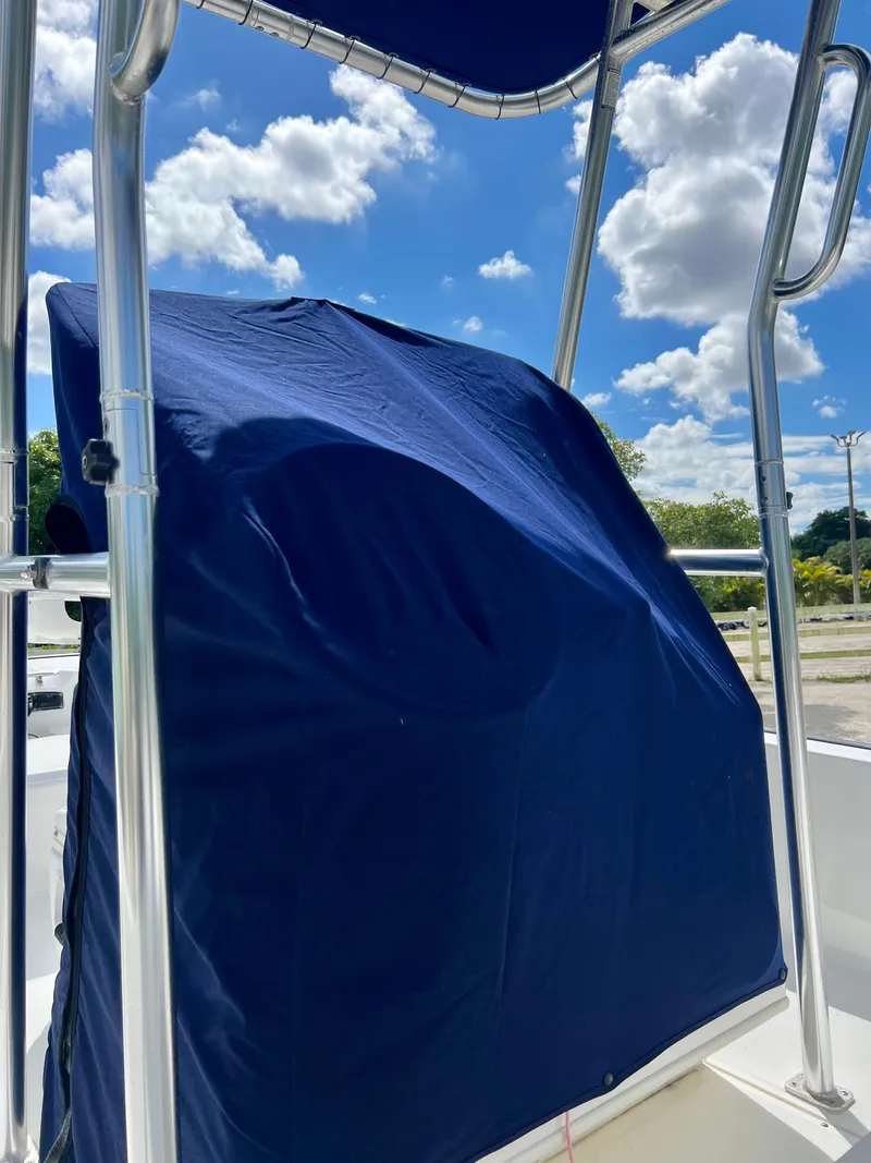 Slide: The Image of 2013 Boston Whaler MONTAUK boat console covered with blue fabric under a sunny sky. - 34