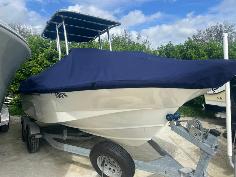 Slide: The Image of 2013 Boston Whaler MONTAUK boat on trailer with blue cover, parked outdoors. - 38