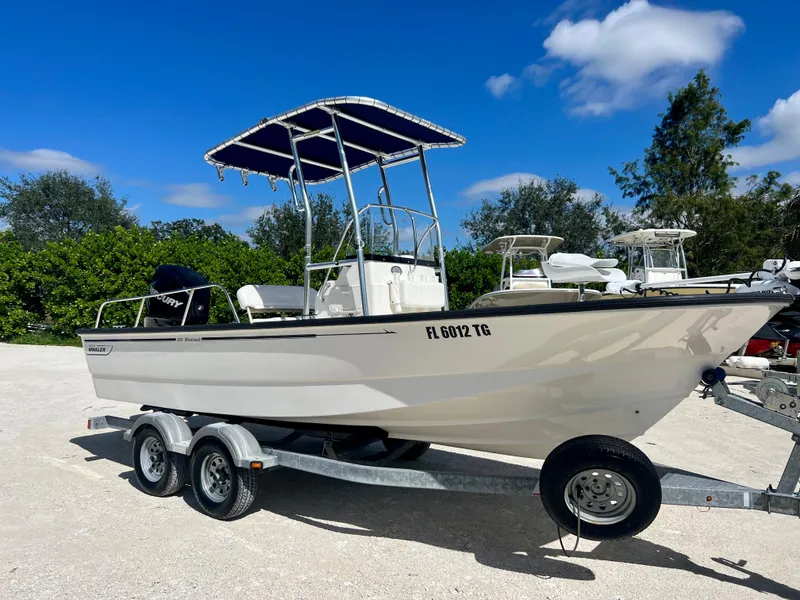 Slide: The Image of 2013 Boston Whaler MONTAUK boat on a trailer with blue canopy. - 6