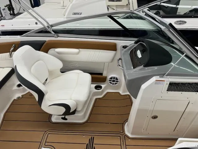 Slide: The Image of 2024 Chaparral 21 SSi boat interior with white and brown seating, modern dashboard, and teak flooring. - 11
