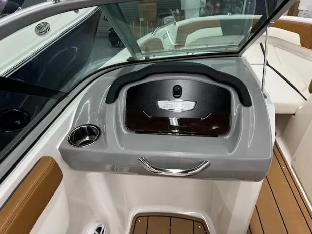 Slide: The Image of 2024 Chaparral 21 SSi boat interior dashboard with cup holder and storage compartment. - 12
