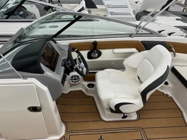 Slide: The Image of 2024 Chaparral 21 SSi boat interior with white captain's seat and modern dashboard. - 9