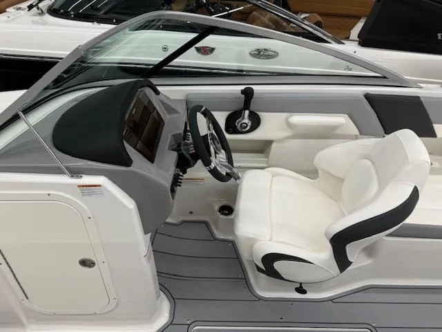 Slide: The Image of 2024 Chaparral 23 SSi boat cockpit with white captain's chair and modern dashboard. - 9