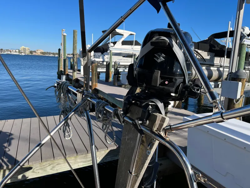 Slide: The Image of Gozzard 36 sailboat at dock, showcasing stern and outboard motor, 1990 model. - 22