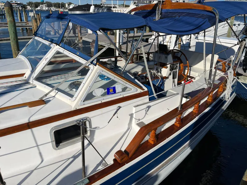 Slide: The Image of 1990 Gozzard 36 sailboat with blue canopy docked at marina. - 3