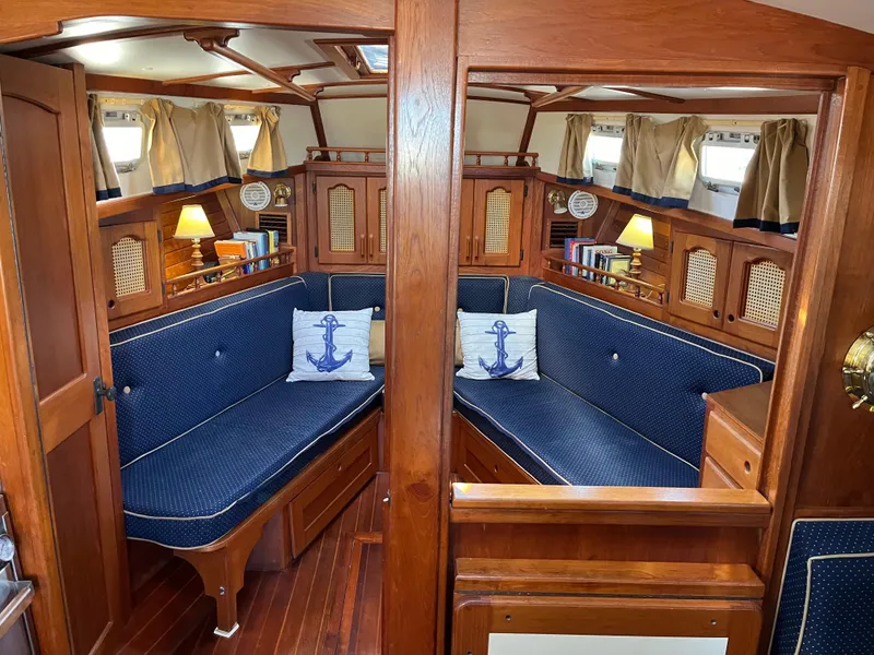 Slide: The Image of Interior of a 1990 Gozzard 36 sailboat with wooden furnishings and blue seating. - 41