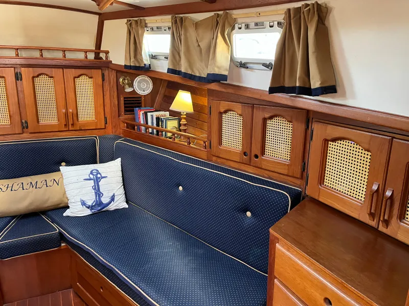 Slide: The Image of Interior of 1990 Gozzard 36 sailboat with blue cushioned seating and wooden cabinetry. - 43