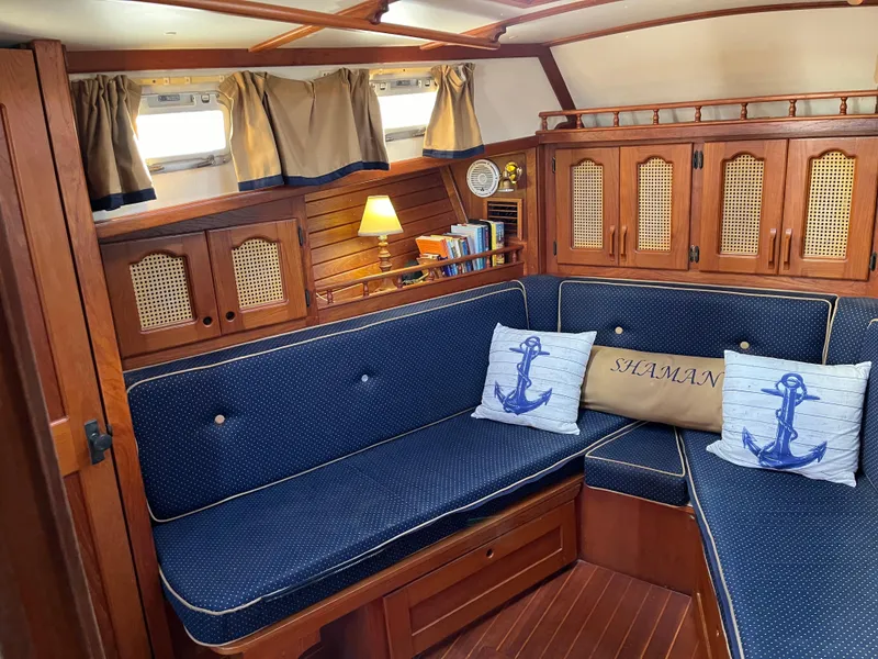 Slide: The Image of Cozy interior of 1990 Gozzard 36 sailboat with blue cushioned seating and nautical decor. - 44