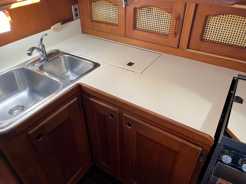 Slide: The Image of Galley kitchen in 1990 Gozzard 36 sailboat with double sink and wooden cabinets. - 47