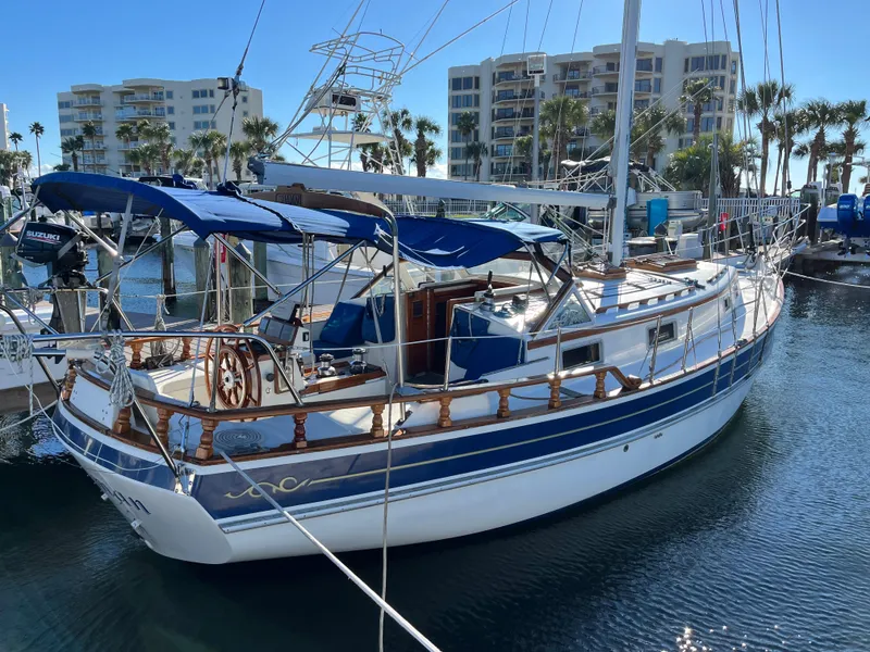 Slide: The Image of Gozzard 36 sailboat, 1990 model, docked at marina with blue canopy and wooden accents. - 5