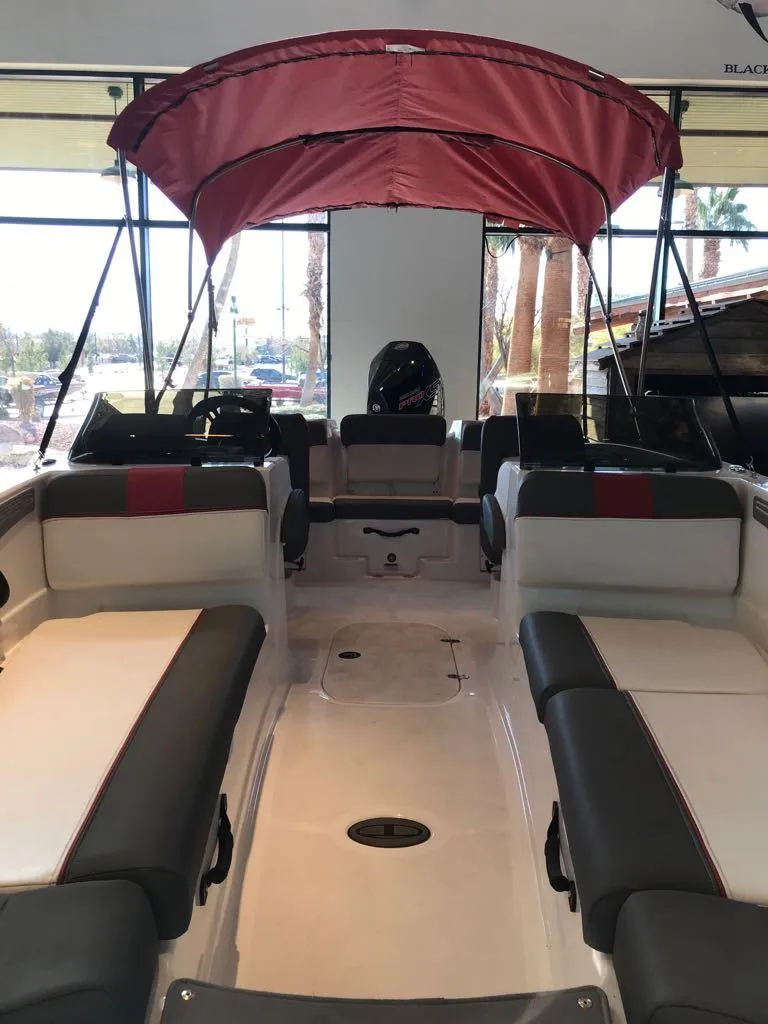 Slide: The Image of 2024 Tahoe T21 boat interior with red canopy and spacious seating. - 7
