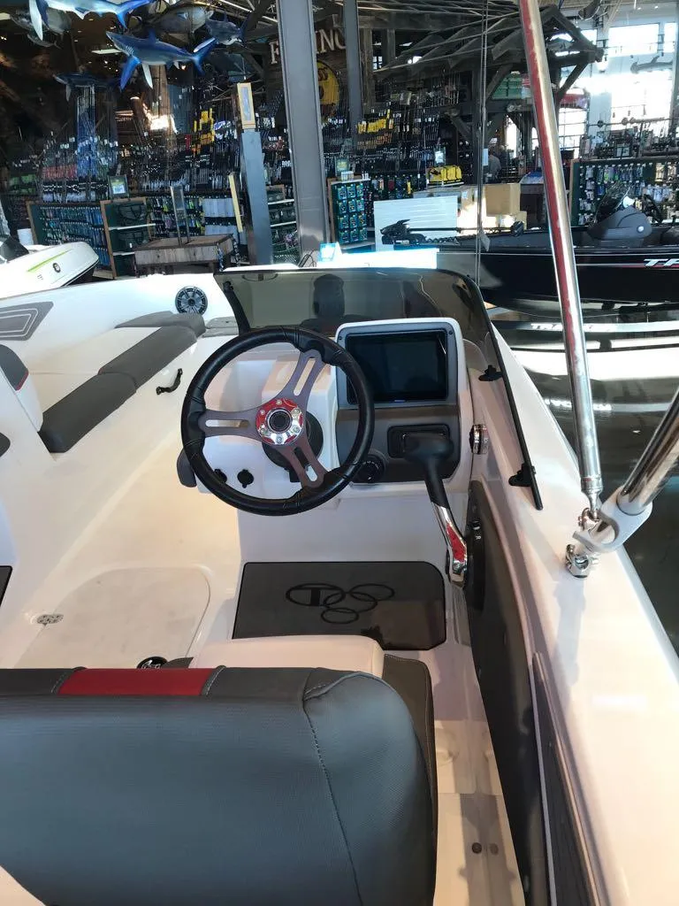 Slide: The Image of 2024 Tahoe T21 boat interior with steering wheel and dashboard in showroom. - 8