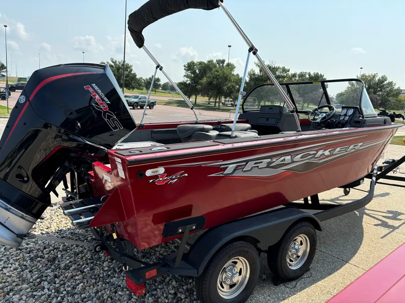 Slide: The Image of 2024 Tracker Targa V-19 WT boat, red exterior, parked on a trailer. - 2