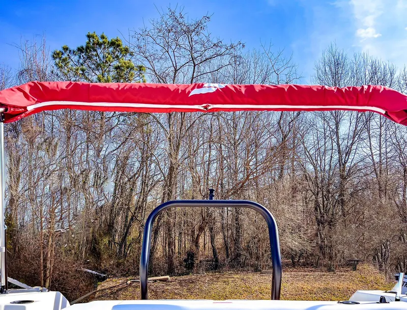 Slide: The Image of 2024 Starcraft SVX 211 OB boat with red canopy in wooded area. - 11