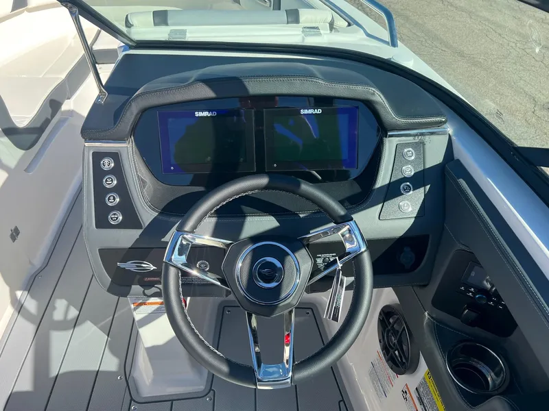 Slide: The Image of 2024 Chaparral 247 SSX boat dashboard with dual Simrad displays and steering wheel. - 3