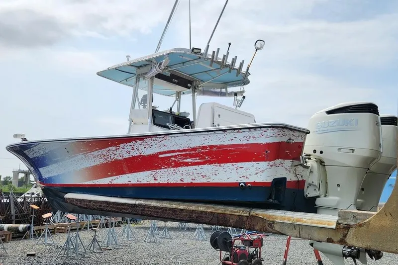 Slide: The Image of 2005 SeaCraft SC32 Master Angler boat with red, white, and blue hull on a trailer. - 2