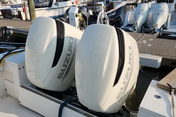 Slide: The Image of Twin Suzuki outboard motors on a 2005 SeaCraft SC32 Master Angler boat at a marina. - 24