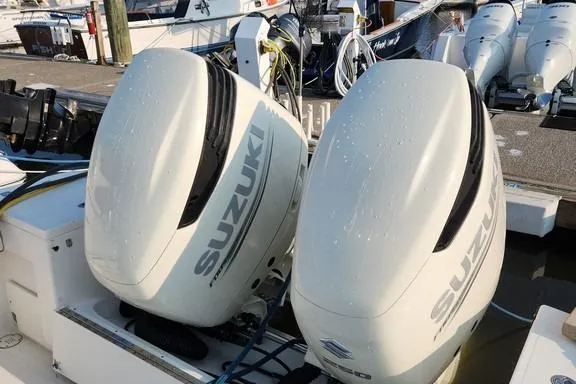 Slide: The Image of Twin Suzuki outboard engines on a 2005 SeaCraft SC32 Master Angler boat at a marina. - 25