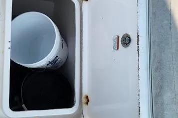Slide: The Image of Open storage compartment on 2005 SeaCraft SC32 Master Angler boat with bucket inside. - 32