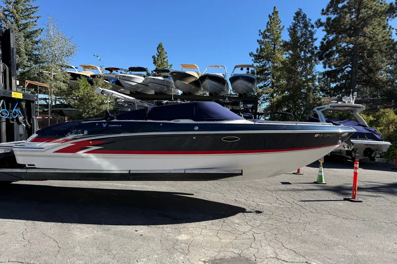 The Image of 2025 Formula 270 Bowrider boat on display, surrounded by trees and other boats. - 0