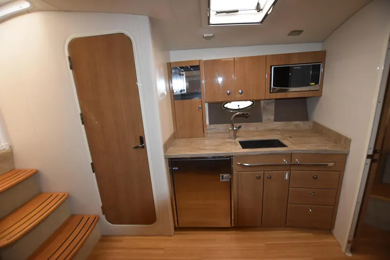 Slide: The Image of 2016 Formula 37 Cruiser kitchen with wood cabinetry, stainless steel appliances, and modern fixtures. - 23
