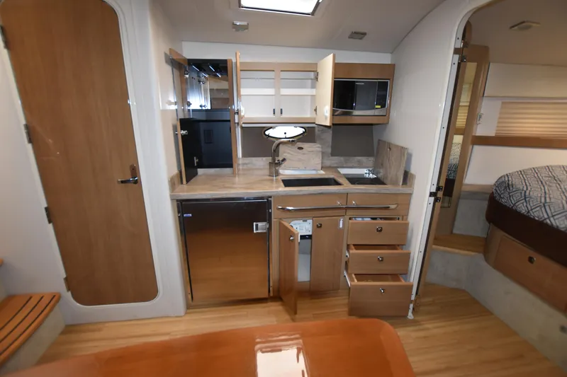 Slide: The Image of 2016 Formula 37 Cruiser kitchen area with modern appliances and wooden cabinetry. - 24