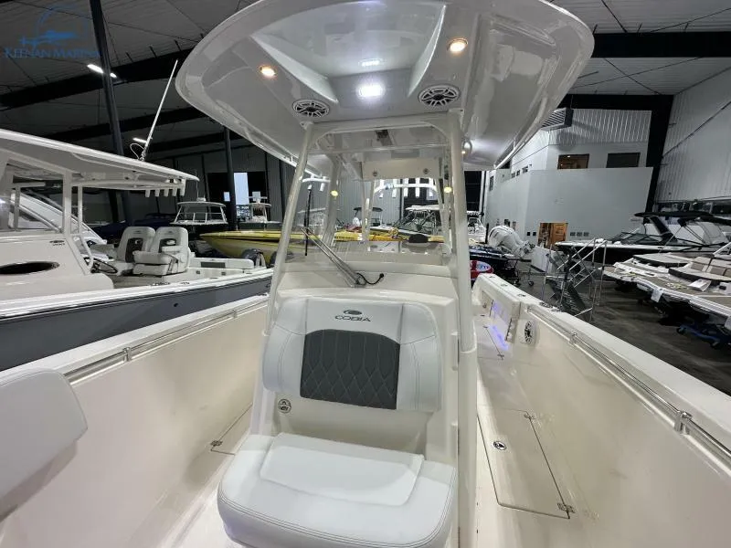 Slide: The Image of 2024 Cobia 301 Center Console in a showroom, featuring a white hull and gray accents. - 13