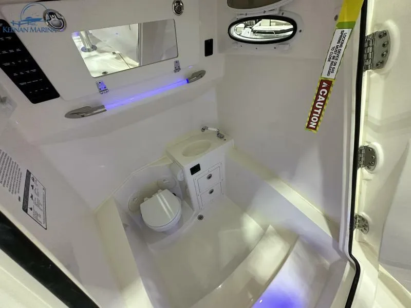 Slide: The Image of Interior of the 2024 Cobia 301 Center Console with toilet and sink. - 14