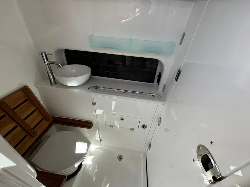 Slide: The Image of 2025 Blackfin 400 CC boat bathroom with modern sink and wooden seat. - 13