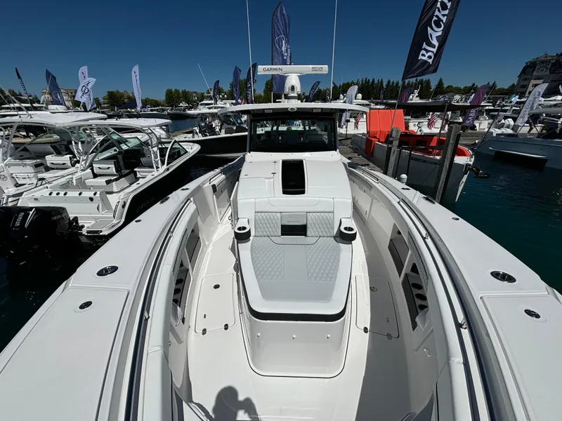 Slide: The Image of 2025 Blackfin 400 CC boat at a marina, showcasing sleek design and spacious deck. - 16