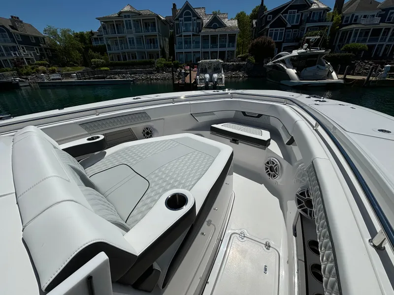 Slide: The Image of 2025 Blackfin 400 CC boat interior with luxurious seating and waterfront homes in the background. - 19